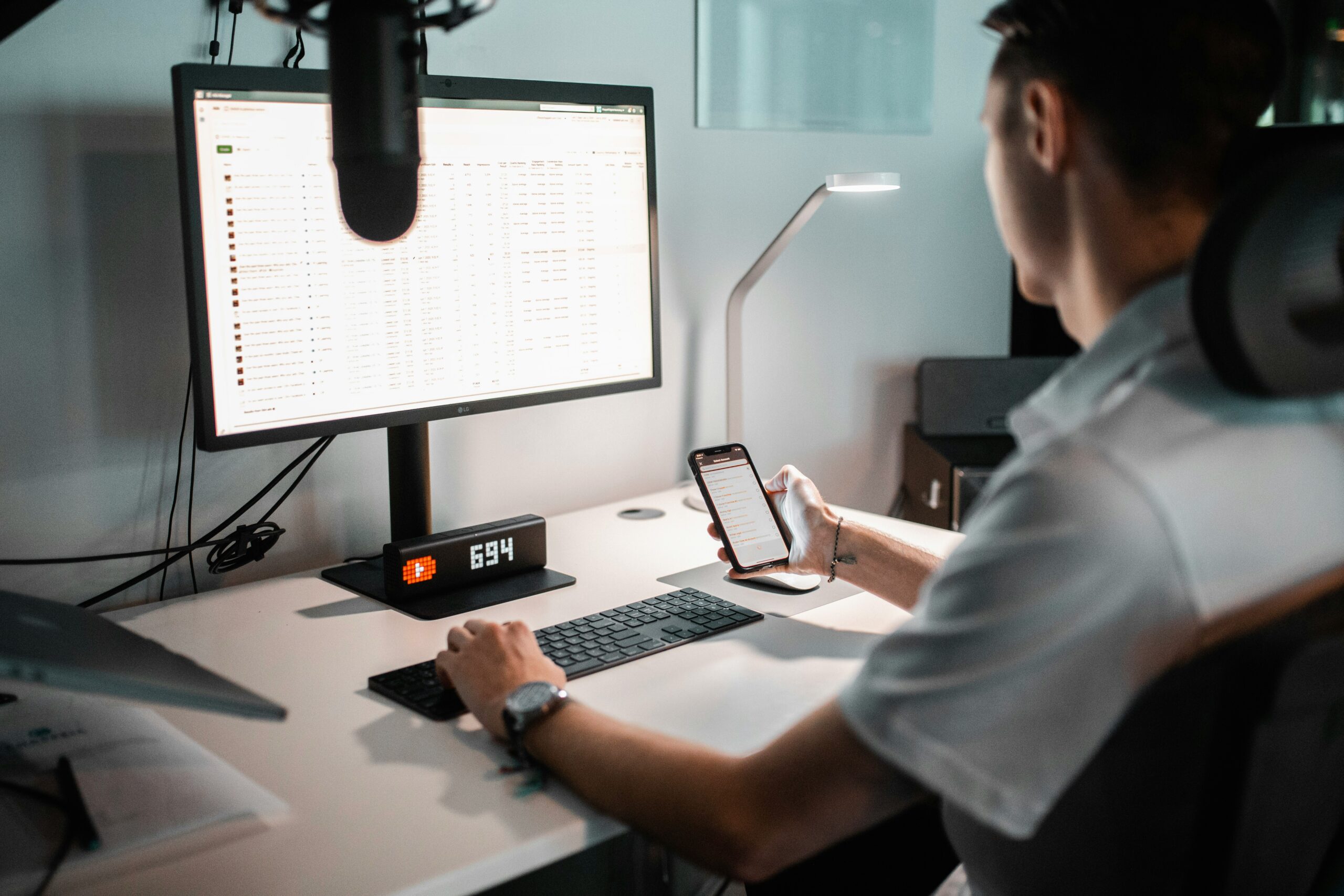 Person at desk using phone and computer